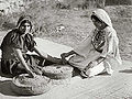 Arab women working hand mill.jpg