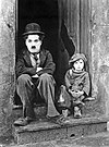 Charlie Chaplin (1889-1977) som sin odödliga komedikaraktär "The Tramp", här mot Jackie Coogan i klassikern "Chaplins pojke" ("The Kid", 1921).