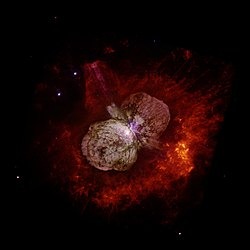 Bild tagen av Hubble Space Telescope som visar Eta Carinae och den bipolära Homunculusnebulosan som omger stjärnan.  Nebulosan är resterna efter det utbrott Eta Car gjorde vars ljus nådde jorden 1843. Eta Car är den vita fläcken nära mitten av bilden, där nebulosans två lober råkas.