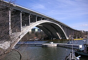 Tranebergsbron var ett annat stort infrastrukturprojekt som realiserades på 1930-talet. Bron invigdes 1934 men på 1990-talet var den stark sliten och klarade inte längre den stora trafikbelastningen. Det beslöts att ett nytt, tredje brovalv skulle byggas och för att bevara stadsbilden intakt bestämdes även att den nya bron skulle likna den gamla. Tranebergsbron byggdes ut och renoverades 1999-2005. Det numera mycket blekta färgfotografi från 1937 togs av Gustaf W. Cronquist.