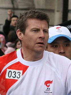 Steve Cram bär den olympiska elden i London 2008.