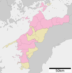 Karta över Ehime prefektur, städer i vinröd ton och köpingar i grått.